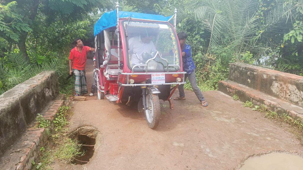 জীর্ণ সেতুতে ঠেলে গাড়ি পার