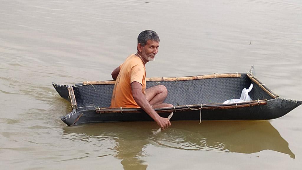 ঘরের চালা দিয়ে বানানো নৌকায় ছুটে যান ত্রান নিতে