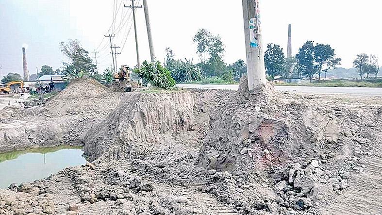 সড়কের মাটি ইটভাটায় ঝুঁকিতে বিদ্যুতের খুঁটি